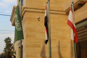 due bandiere volano davanti a un edificio di Virginia Hotel ad Amman