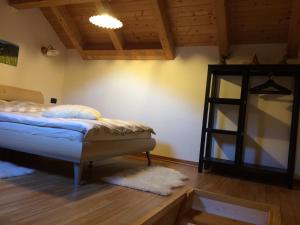 a bedroom with a bed and a wooden floor at Appartamentino Frundsberg in Vipiteno