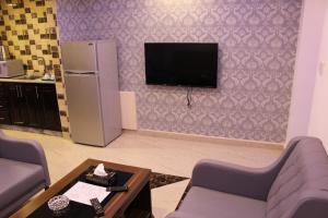 un soggiorno con frigorifero e TV a parete di Virginia Hotel ad Amman