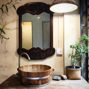 ein Badezimmer mit einer Holzbadewanne und einem Spiegel in der Unterkunft Boundary Hostel and Cafe in Surat Thani
