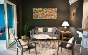 een woonkamer met een bank, een tafel en stoelen bij Tropic'Alizé, - superbe T3, piscine, à 2 min du lagon de L'Hermitage in Saint-Gilles-les-Bains