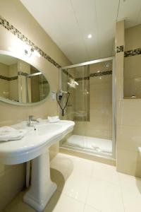 a bathroom with a sink and a shower at Hôtel Le Royal Promenade des Anglais in Nice