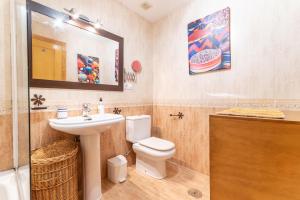 a bathroom with a sink and a toilet and a mirror at Apartamento la Isletilla in Almería
