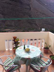 a table with two chairs and a bottle of wine on a balcony at Casa Cira in Calera