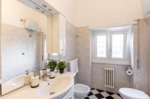 ein Badezimmer mit einem Waschbecken, einem WC und einem Spiegel in der Unterkunft Liberty Trastevere B&B in Rom