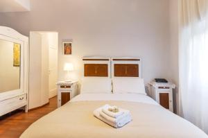 Un dormitorio con una cama blanca con toallas. en Liberty Trastevere B&B, en Roma