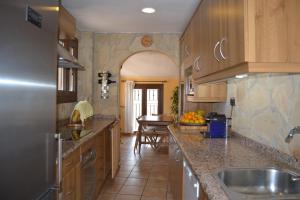a kitchen with wooden cabinets and granite counter tops at Marquesa de las Jarras in Teruel