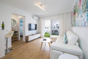 een witte woonkamer met een witte bank en een tafel bij Flower Beach Suite 1 in Playa Honda