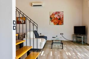 a living room with a couch and a tv at Estrella Villas in Lartos