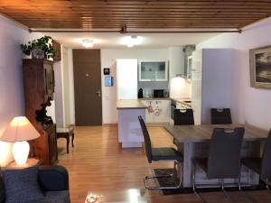 a living room and kitchen with a table and chairs at Appartementhaus-Quadern in Valens