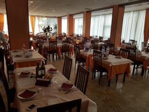 una sala da pranzo con tavoli, sedie e bottiglie di vino di Hotel Fabius a Rimini