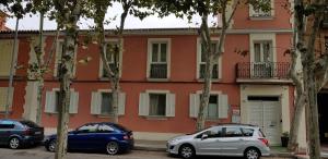 dwa samochody zaparkowane przed budynkiem w obiekcie Casa de Huéspedes con encanto El Sueño del Quijote w mieście Alcalá de Henares
