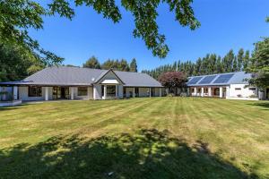 una grande casa con pannelli solari su un cortile di BOND ESTATE LUXURY ACCOMMODATION a Christchurch