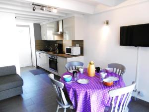 サルゾーにあるMaisonnette Lizigのキッチンに紫のテーブルクロス付きテーブル