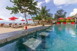 a pool at a resort with chairs and umbrellas at la plage resort & beach club in Baan Tai +46 photos