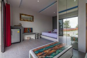 Habitación con dormitorio con cama y espejo. en la plage resort & beach club, en Baan Tai