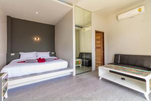 a bedroom with a white bed and a mirror at la plage resort & beach club in Baan Tai