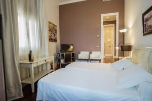 una camera d'albergo con due letti e una televisione di Hotel Palacio Garvey a Jerez de la Frontera