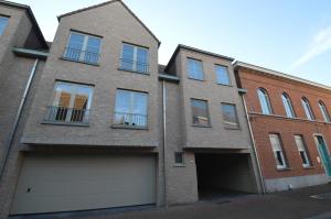 a brick building with a garage in front of it at Ars Vivendi in Moerbeke