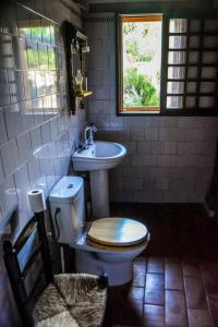 a bathroom with a toilet and a sink and a window at EL PAJAR DE ANGELINES in Tocon De Quentar