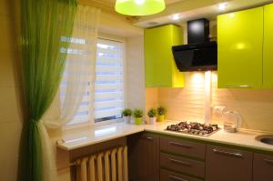 a kitchen with green cabinets and a stove and a window at Luxury 2 Rooms Apartments in Center by Green House in Poltava