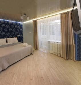 a bedroom with a bed and a large window at Luxury 2 Rooms Apartments in Center by Green House in Poltava