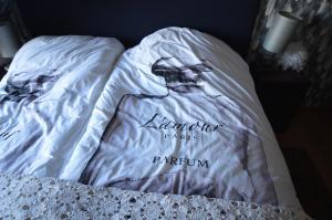 una cama con un edredón blanco con las palabras emperador partidos parnin en Ars Vivendi, en Moerbeke