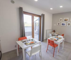 a dining room with a white table and chairs at Villa Ulivi B&B in Pontecagnano +15 photos