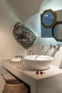 a bathroom with a sink and a mirror on a counter at Cocoon Suites in Imerovigli