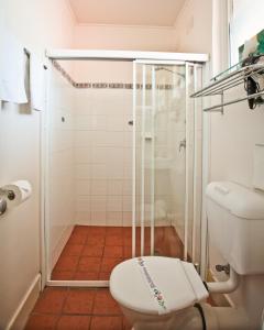a bathroom with a shower and a toilet in it at Abbotsleigh Motor Inn in Armidale