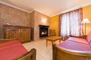 a bedroom with two beds and a fireplace at La Remontée Appartements Hôtel in La Malbaie