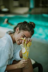 a man is biting into a drink with a straw at Hotel Premier Aqua - Adults Only in Vrdnik