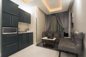 una pequeña sala de estar con sofá y mesa. en Al Muhaidb Residence Al Takhassusi, en Riad