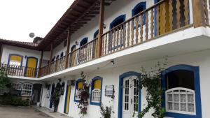 a building with blue and yellow doors and a balcony at Pousada Recanto da Cleide in Paraty