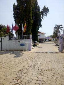a cobblestone street with flags on a fence at Eastoment Hotel in Accra