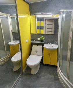 uma casa de banho amarela com 2 WC e um lavatório em Yellow Loft Luxury apartments with 2 bedrooms em Poltava