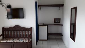 a room with a bed and a television on a wall at Pousada Recanto da Cleide in Paraty