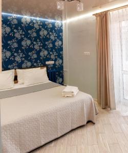 1 dormitorio con 1 cama con pared azul en Luxury 2 Rooms Apartments in Center by Green House en Poltava