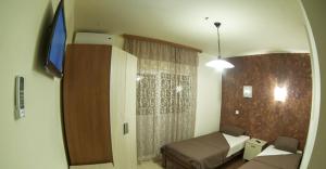 Habitación pequeña con cama y espejo. en Prenoćište Trio en Vranje