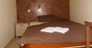 una camera da letto con un letto e due asciugamani di Prenoćište Trio a Vranje