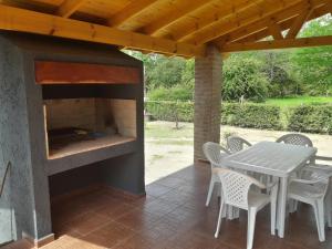 a fireplace on a patio with a table and chairs at Der Wald cabañas in Los Reartes