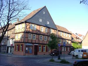 un grand bâtiment en bois avec un toit noir dans l'établissement Hostel Schützenbrücke, à Quedlinbourg