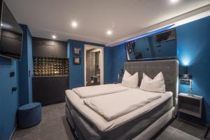 Schlafzimmer mit blauen Wänden und einem Bett mit weißer Bettwäsche in der Unterkunft Apartment Zentral im Herzen der Altstadt in Tübingen