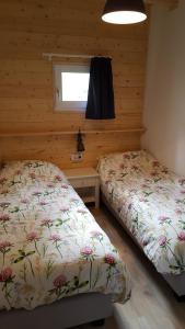 a bedroom with two beds and a window at Chalet in Castricum