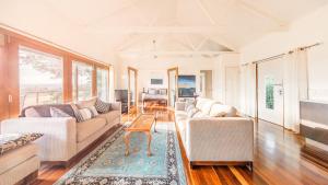 a living room with two couches and a table at Outlook Hill Vineyard Cottages & Suites in Healesville