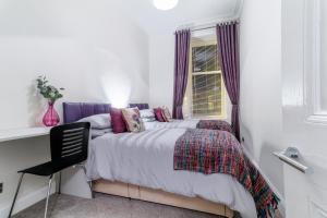 a bedroom with a bed and a window at West Highland Apartments Milngavie - The Nevis in Milngavie