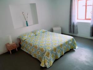 1 dormitorio con 1 cama con colcha amarilla y ventana en Casa I Love Huaraz en Huaraz