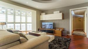 a living room with a couch and a flat screen tv at Downtown Design Apartment in Donostia-San Sebastián