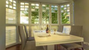 a dining room with a white table and windows at Downtown Design Apartment in Donostia-San Sebastián