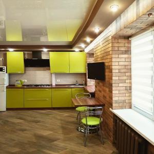 波爾塔瓦的住宿－Luxury Loft в центре Полтавы，厨房配有绿色橱柜和桌椅